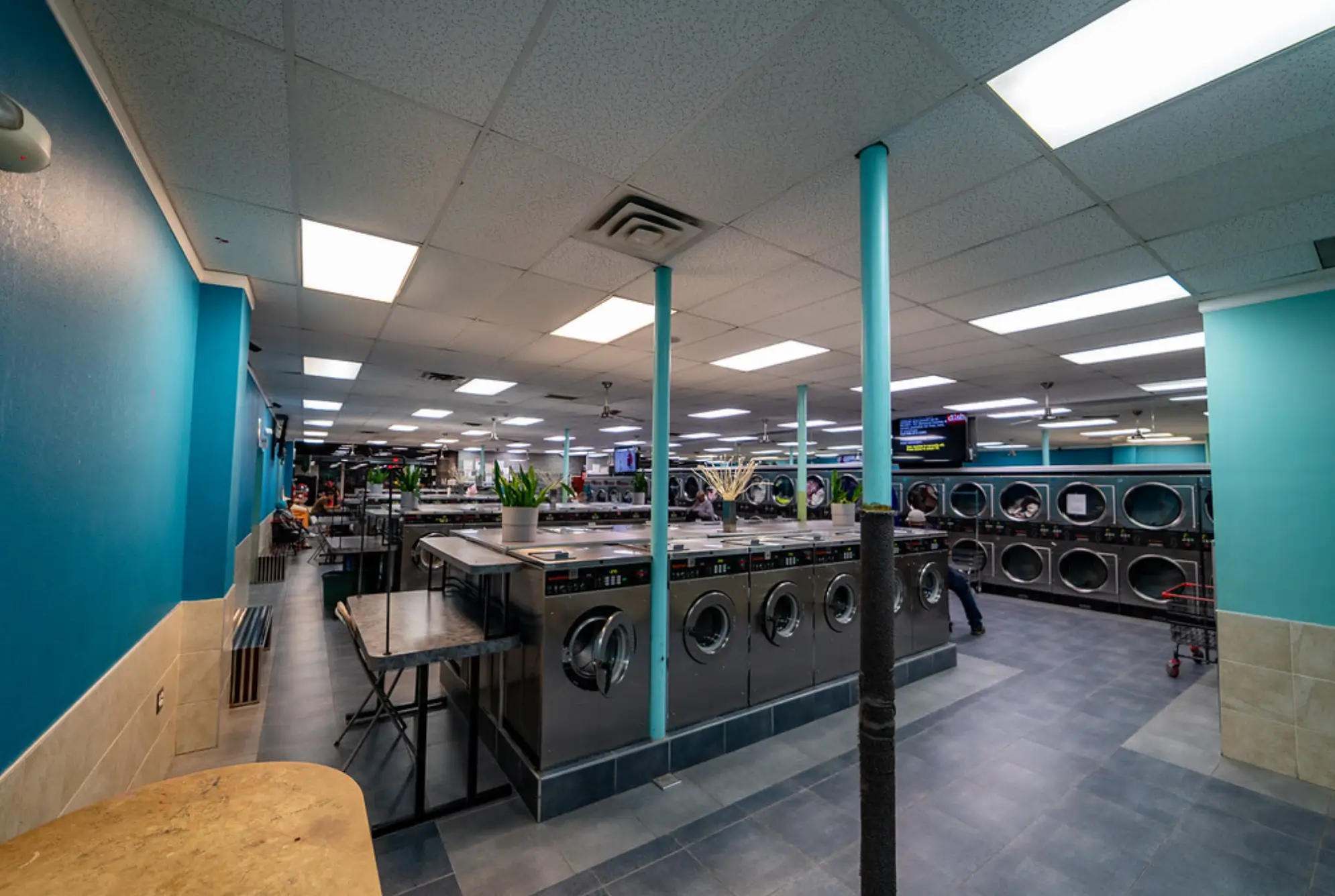 Row of commercial washing machines inside Rose Hill Wash laundromat